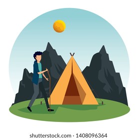 man walking with stick and camp with mountains and sun