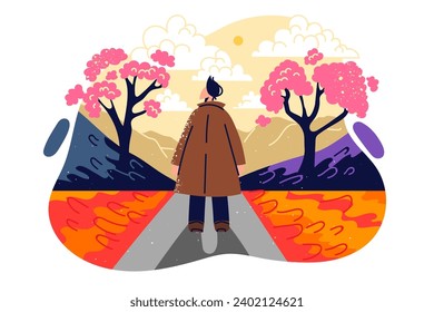 Un hombre camina por un parque de otoño con un sakura floreciente viajando por japón y se para de pie con el paisaje admirador de la vuelta a la cámara. Parque otoñal con peatón disfrutando de la contemplación de la naturaleza