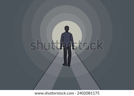 Man walks through dark tunnel towards exit, striving to achieve success and get out of problematic situation. Lonely guy sees light at end of tunnel, walking along mysterious path.
