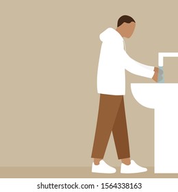 A man washes his hands under the tap with water