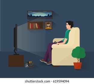 The Man Is Watching TV In A Dark Room. There Are Cat And A Flower Next To The Guy. 