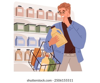 Un hombre con gafas está comprando detergente en una tienda de comestibles, examinando una botella mientras está de pie frente a estantes llenos de varios productos de limpieza. Toma de decisiones en las compras al por menor.