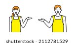 A man and a woman in aprons with one hand raised, smiling and giving directions.