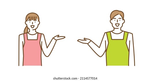 A man and a woman in aprons with one hand raised, smiling and giving directions.
