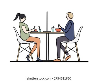 Man and woman dine and maintain social distancing with partition at restaurant to prevent and protect covid-19 coronavirus