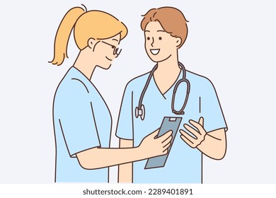 Man and woman dressed as doctors are discussing with smile treatment of patient or correct diagnostic measures. Guy with girl work as doctors surgeons in hospital and build career in field of medicine