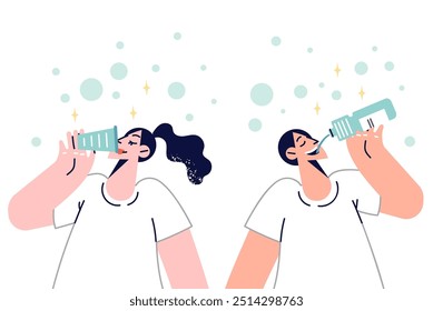 Man and woman drink fresh water from mineral spring to refresh themselves on hot summer day. Concept of importance of drinking purified water and using filter to obtain good quality aqua