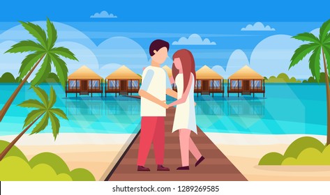man woman embracing happy lovers on tropical beach water bungalow houses landscape summer travel vacation honeymoon concept couple in love full length horizontal flat