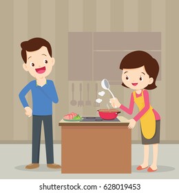 Man and woman in the kitchen.Husband look at wife cooking in the kitchen.