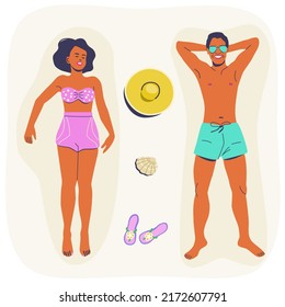Man and woman lying on a beach, getting suntan, aerial view. Beautiful couple on summer vacation.