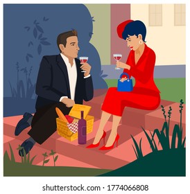 Man and woman on a picnic drink wine in the park.