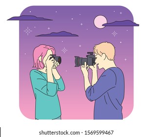 Man and woman photographing each other with a camera. Night sky background romantic atmosphere. hand drawn style vector design illustrations. 