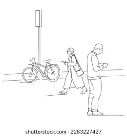 Man and woman using phones on street with road sign and parked bicycle.