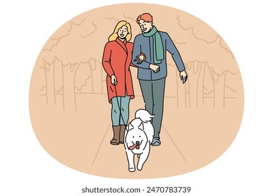 Hombre y mujer están paseando a su perro juntos en el parque disfrutando de un paseo en la tarde de otoño con Clima cálido. Pareja feliz con perro blanco con correa cuidar mascota en necesidad de caminar al aire libre a tiempo