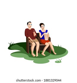 A man and a woman watch a movie on the street in chairs from a regular movie theater. Outdoor movie theater. A cinema in nature for lovers and a large group of friends. Useful pastime with loved ones
