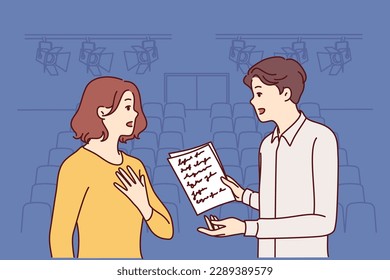 Man and woman working as actors are rehearsing theatrical performance standing on stage. Guy and girl are memorizing text of theatrical performance, wanting to receive award for acting 