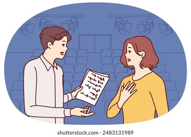 Man and woman working as actors are rehearsing theatrical performance standing on stage. Guy and girl are memorizing text of theatrical performance, wanting to receive award for acting