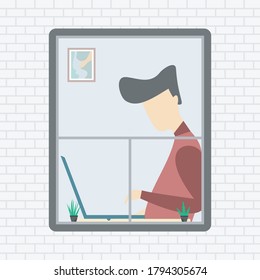 A man working at the computer seen from the window