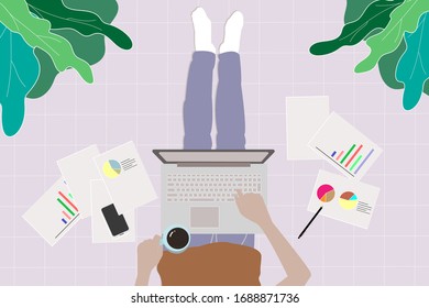Man working from home with smart phone and laptop lying on floor. Working home concept.