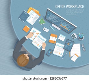 Man working in office at the round table. Workplace Desktop Workspace Chair, business office supplies, documents, monitor, calendar, notepad, folder, envelope, books. Charts, graphics on the screen 

