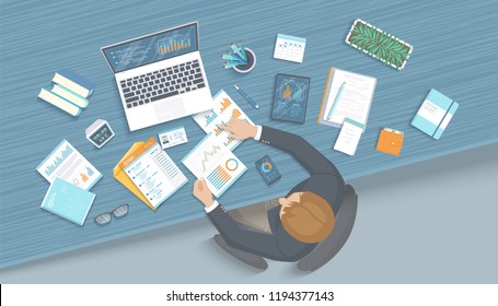 Man working in office at the table. Workplace Desktop Workspace Armchair, business office supplies, laptop, documents, tablet, notepad, folder, envelope, books. Charts, graphics on the screen. Vector