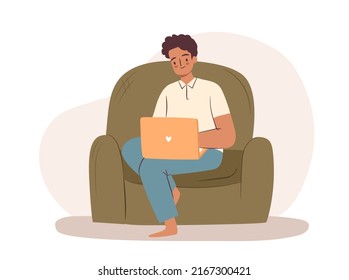 Man working on laptop in armchair