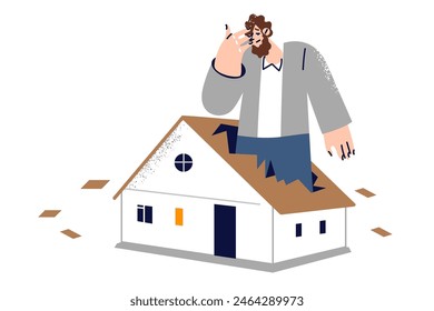 Man worried about insufficient size of housing, stands inside fire in broken roof of small house. Guy housing problem is caused by lack of money for rent or high mortgage interest rate.