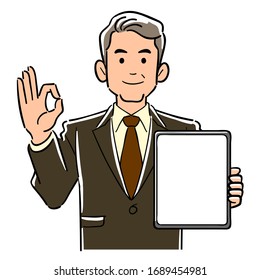 Ein Manager in einem Anzug, der einen Tablet-PC mit einem leeren Bildschirm und einem OK-Zeichen hält