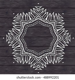  Mandala on the wooden background. 
 White outline mandala.