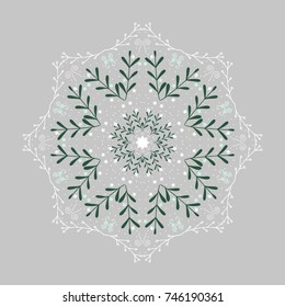 Mandala snowflake on a gray background with green twigs.