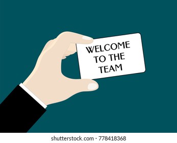 A man's hand (businessman) holds a card with words "Welcome to the team"