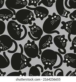 many different stylized black cats randomly arranged. seamless vector pattern