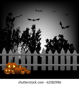 Many pumpkins next to the wooden fence