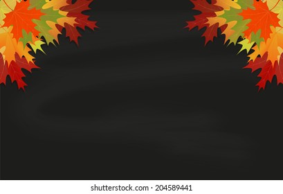 Maple leaves on black chalkboard with chalk 