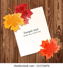 Maple leaves with paper sheet on wooden background texture. EPS 10 vector illustration. Contains transparency effects.