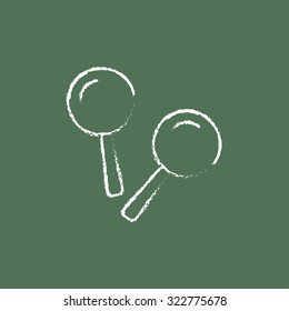 Maracas hand drawn in chalk on a blackboard vector white icon isolated on a green background.