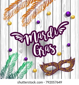 Mardi Gras abstract with ribbons, mask, feather  and banner on the wooden background. Eps 10 vector file.