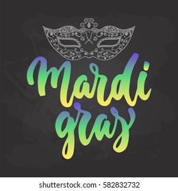 Mardi Gras - hand drawn carnival lettering phrase isolated on the black chalkboard background. Fun brush ink inscription for photo overlays, greeting card or t-shirt print, poster design