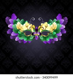 Mardi Gras Mask Of Green, Purple And Yellow Feathers On Black Background.