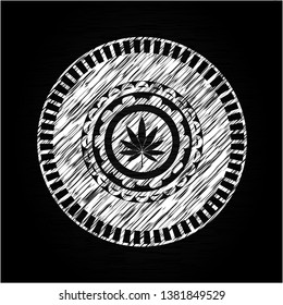 marijuana leaf icon inside chalk emblem written on a blackboard