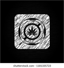 marijuana leaf icon inside chalkboard emblem written on a blackboard