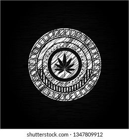 marijuana leaf icon inside chalkboard emblem on black board