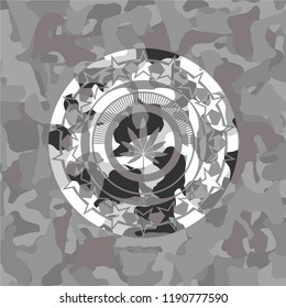 marijuana leaf icon inside grey camouflage emblem