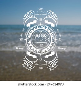 marine background with compass label on blue sky sea shore blur photo