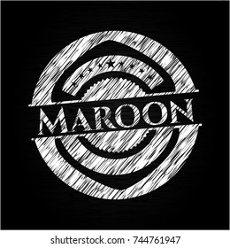 Maroon chalk emblem written on a blackboard