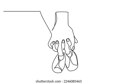 married couple pregnant hands holding baby shoes