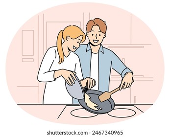 Married couple prepares breakfast enjoying sunday morning and experiencing happiness from communicating with loved one. Happy couple of man and woman cooking pancakes or omelet together