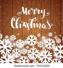Marry Christmas lettering phrase with White Snowflakes on Wooden Planks Background. 