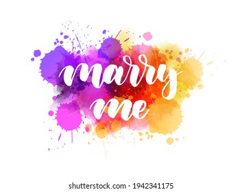 Marry me - handwritten modern calligraphy lettering on multicolored watercolor splash background. Inspirational handlettering for marriage proposal. 