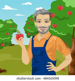 mature farmer man holding an apple in orchard
